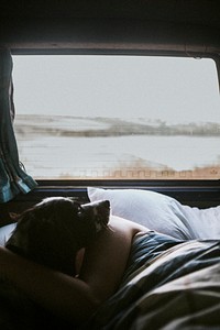 Woman sleeping in a car with her dog