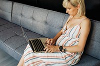 Expecting mother using a laptop at home