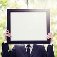 Businessman outdoors holding an empty placard