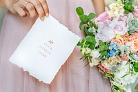 Bride holding a card mockup with a bouquet of flowers