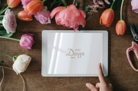 Tablet screen mockup among flowers