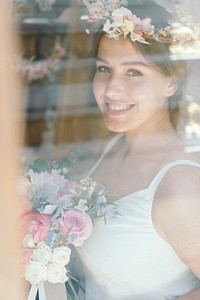 Smiling woman wearing a flower wreath and holding a bouquet of assorted flowers