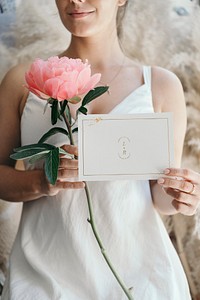 Bride with a coral sunset peony and a wedding invite