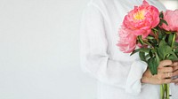 Woman holding a bouquet of peonies
