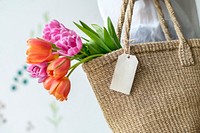 Woman carrying tulips in a wicker bag