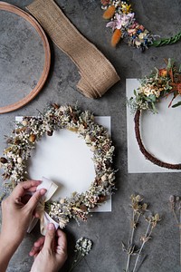 Woman tying a ribbon on a floral wreath