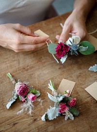 Hands creating boutonnieres with paper tags