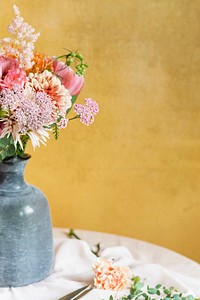 Flowers in a vase by a yellow wall