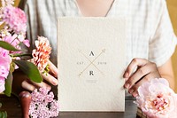 Woman holding a card mockup surrounded by flowers