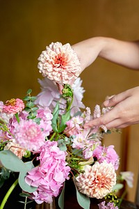 Florist arranging bouquet with pip salmon