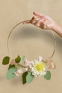 Woman holding a gold frame decorated with flowers