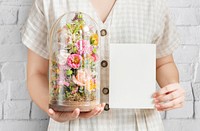 Woman holding a terrarium with a blank card mockup