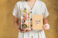 Woman holding a terrarium with a thank you card mockup