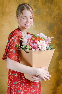 Woman carrying a bouquet of flowers in a paper bag