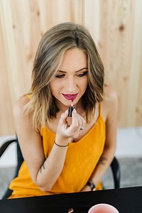Blond beauty blogger applying liquid lipstick