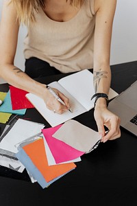 Female fashion designer writing on her notebook