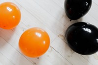 Orange and black balloons on the white wooden floor