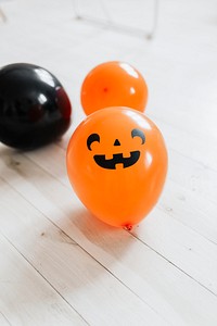 Orange and black Halloween balloons on the white wooden floor