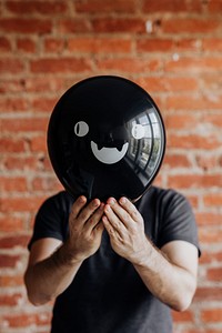 Man holding a cute black Halloween balloon