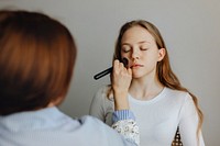 Beauty blogger applying liquid foundation to her model