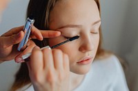 Beauty blogger applying mascara to her model