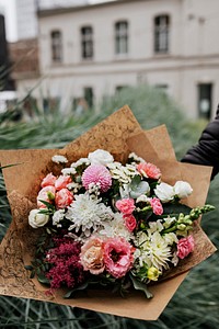 Man holding a bouquet of colorful flowers
