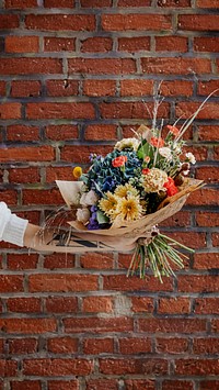 Bouquet of colorful flowers in front of brick wall