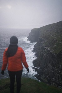 Rear view of woman standing near the cliff at Isle of Skye, Scotland