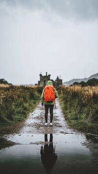 Rear view of a woman in front of Kilchurn Castle, Scotland mobile phone wallpaper