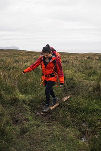 Female hiker walking through a grass field