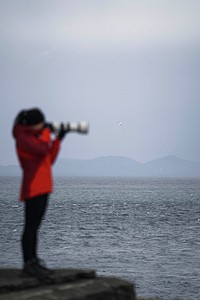 Female photographer at Vaternish Lighthouse on Isle of Skye, Scotland