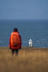 Female traveler at Vaternish Lighthouse on Isle of Skye, Scotland