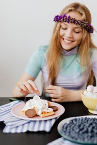 Happy woman eating marshmallow on her waffles 