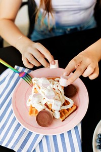 Woman decorating her waffles with marshmallows