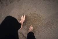 Woman stepping on a sandy beach at Plemont Bay, Isle of Jersey