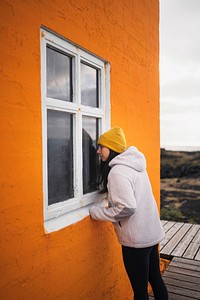 Female traveler at an orange Lighthouse, Iceland
