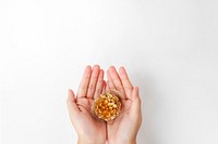 Woman holding a gold conifer cone on her palm