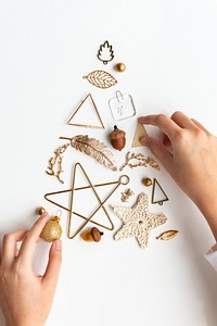 Woman making a Christmas tree with gold ornaments aerial view