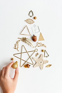 Woman making a Christmas tree with gold ornaments aerial view