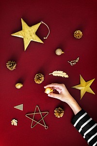 Woman making a Christmas tree with gold ornaments aerial view