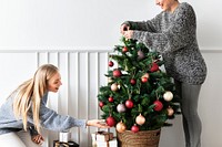 Woman decorating a Christmas tree with ornaments