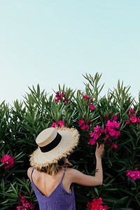 Girl with a straw hat near the shurb