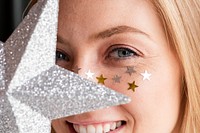 Woman holding a glittery silver star Christmas ornament