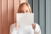 Woman in a white sweater holding a card mockup