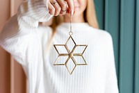 Woman showing a gold snowflake Christmas ornament