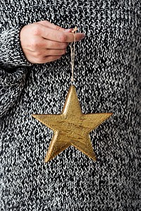 Woman holding a glittery gold star Christmas ornament