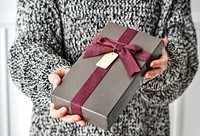 Woman holding a gray present with a card