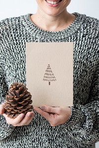 Woman in a gray sweater holding an earth tone card mockup