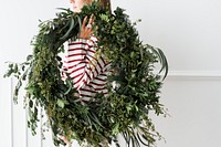 Woman carrying a fresh Christmas wreath