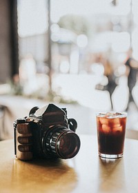 Iced Americano and an analog 120mm camera at a cafe table